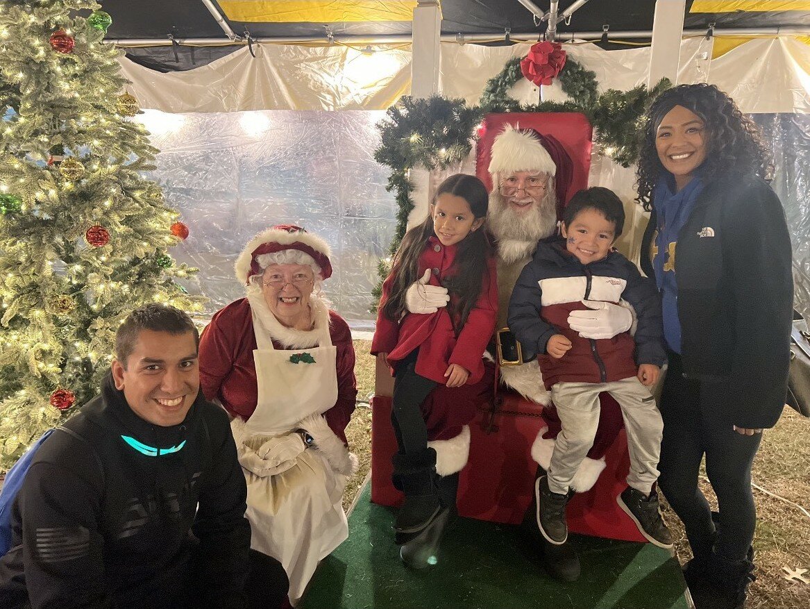 Members of the author's family (from left: Corey Kremer, Lyla and Lincoln) pose with her and with Mr. and Mrs. Santa Claus.