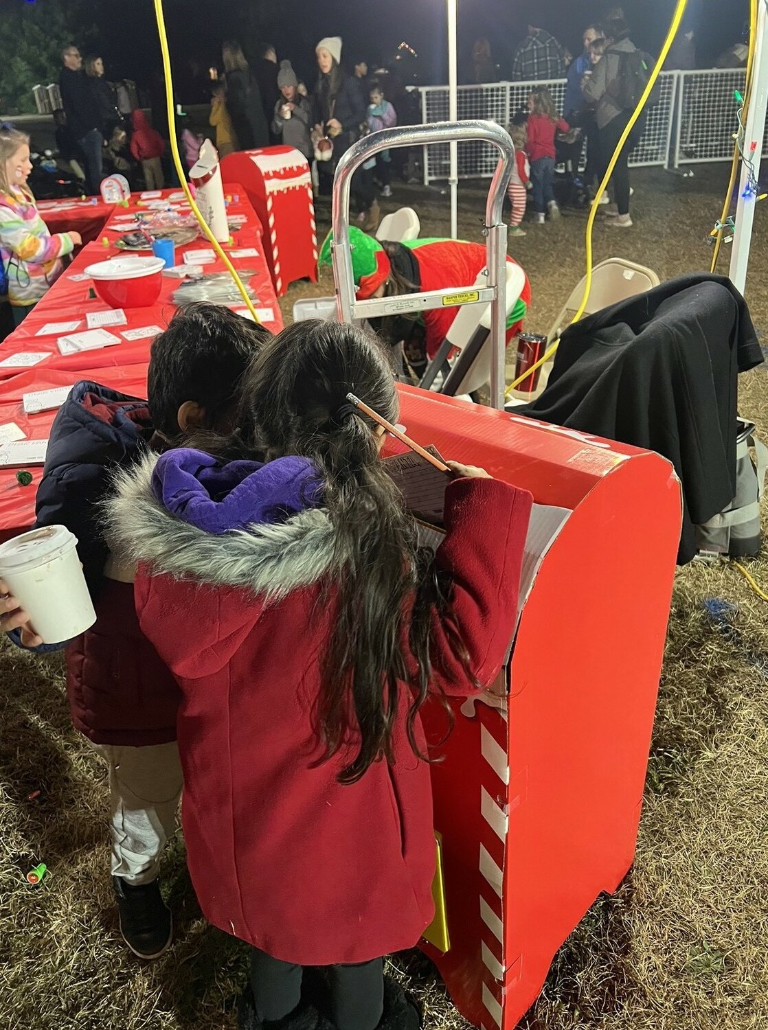The author's children slide a letter to Santa Clause in the 'Letters to Santa' mailbox.