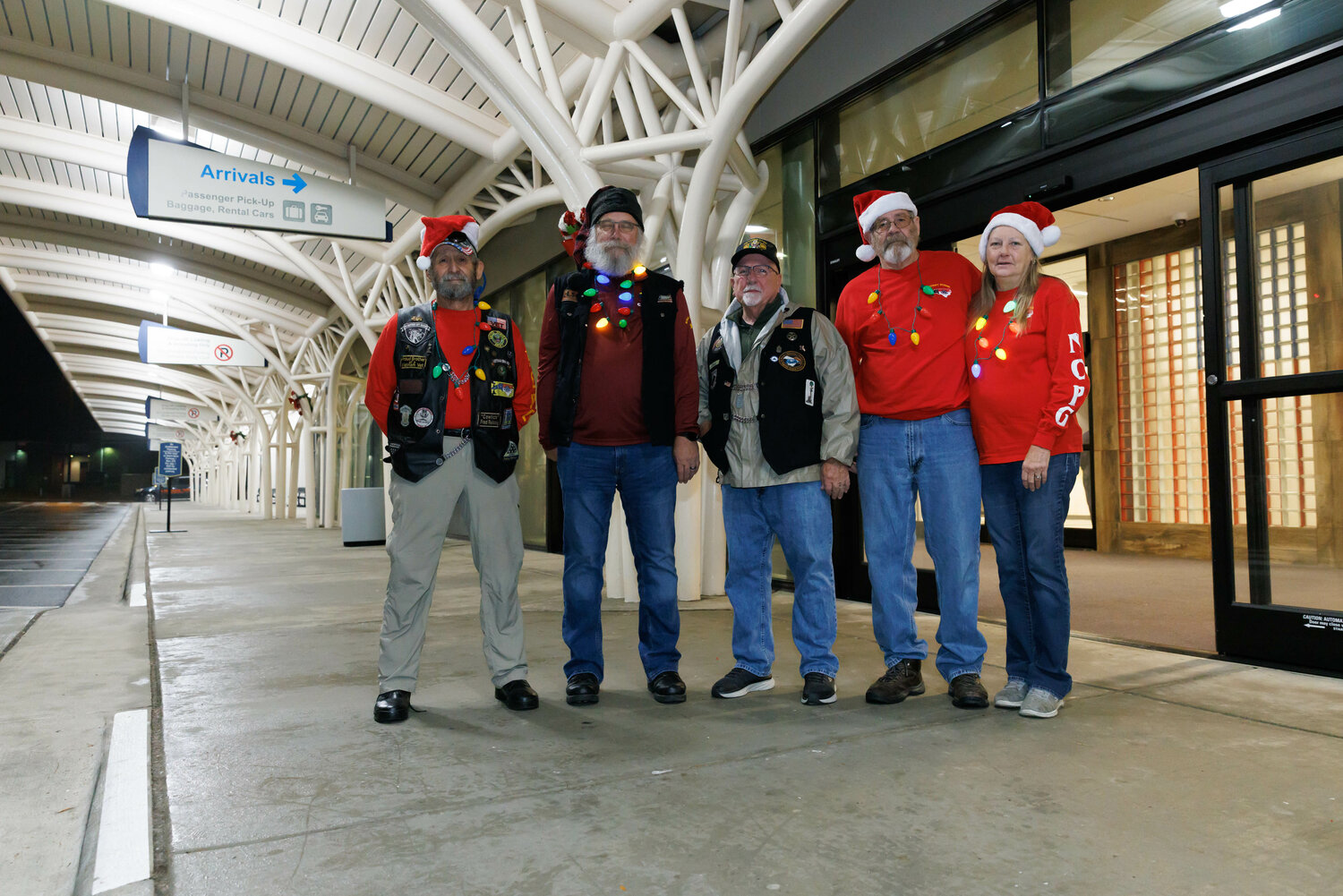 Fred Reissig, Dean Burgess, Ken Vangalder, Dan McPherson, and his wife Carolyn of the Patriot Guard Riders prepare to help families with their luggage as they arrive at the airport on Dec. 2, 2023.