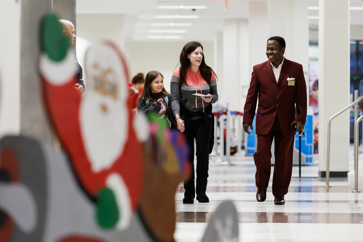 Airport Director Dr. Toney Coleman (right) welcomes Rebecca Boniface and her daughter Mia (left) as they arrive for the Snowball Express on Dec. 2, 2023.