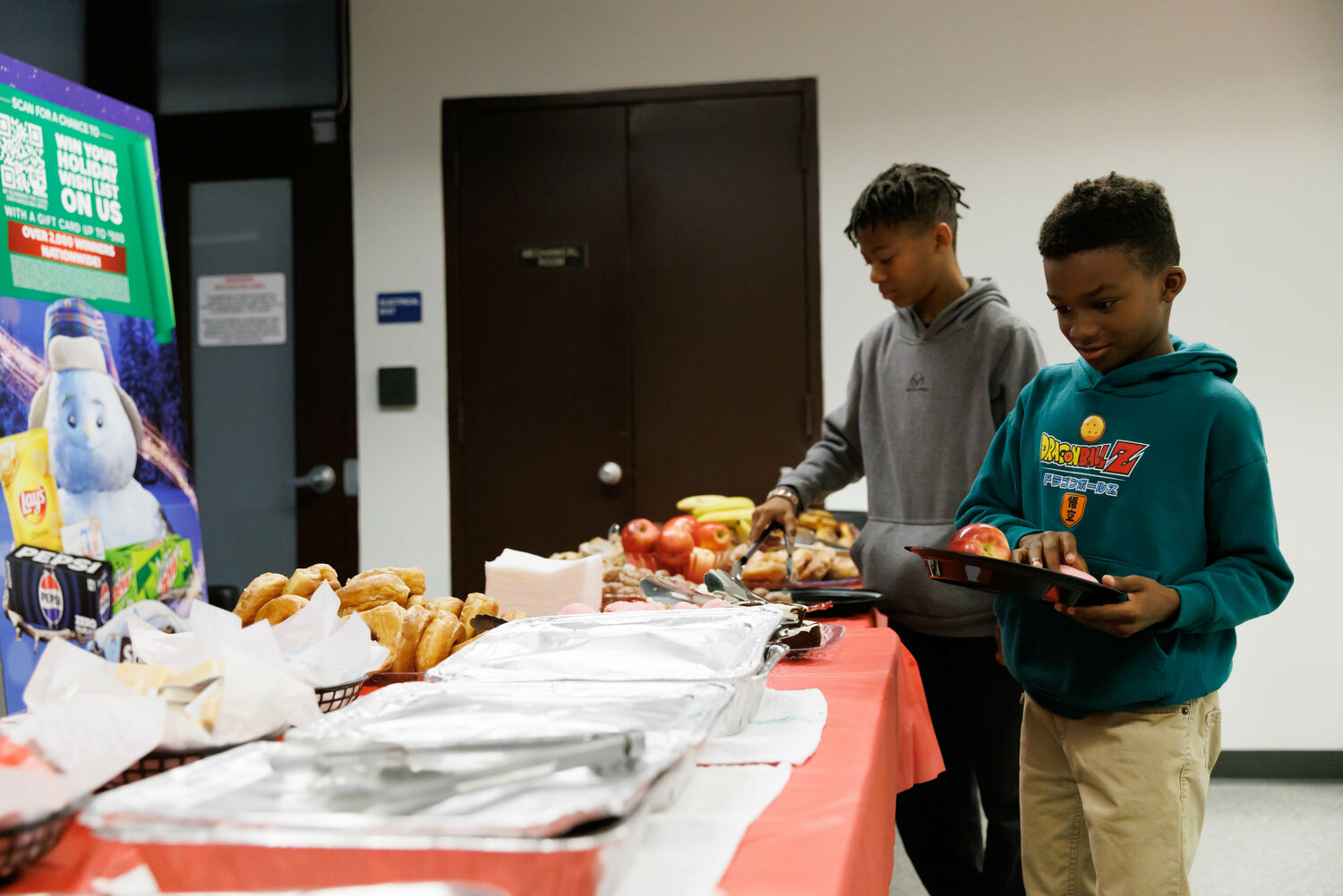 John (right) and Matthew Tibbs enjoy food provided by Superior Bakery as they wait for the arrival of the Snowball Express on Dec. 2, 2023.
