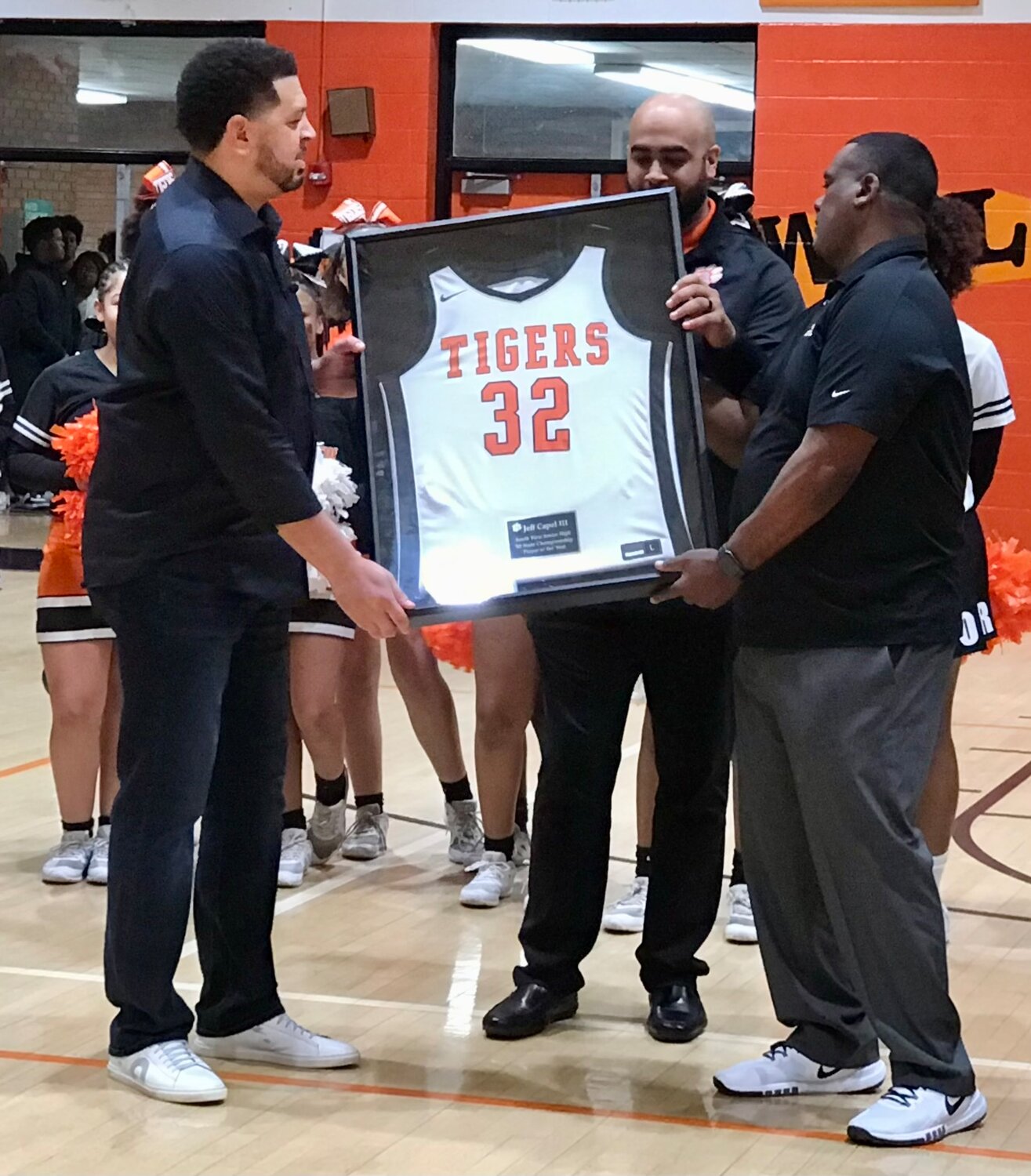 Jeff Capel III, left, receives his retired jersey from South View athletic director James Blue, center, and Tiger varsity football coach Rodney Brewington, right.