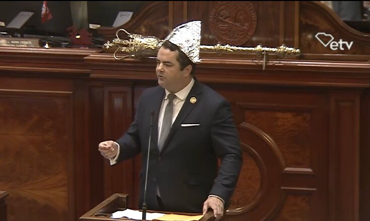 Rep. Micah Caskey, R-West Columbia, wears a tinfoil hat as he mocks members of the hardline conservative Freedom Caucus on Wednesday, May 8, 2024. (Screenshot from SCETV legislative livestream)