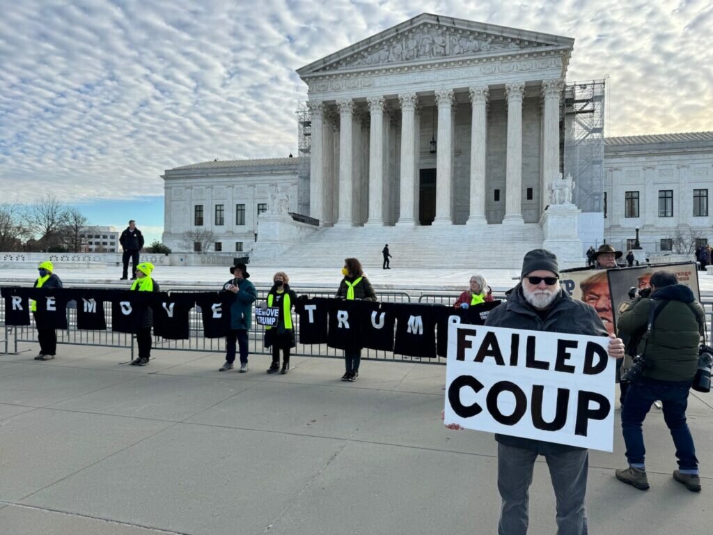 Bill Christenson of Washington, D.C., holds a sign that says “Failed Coup” outside the U.S. Supreme Court on Feb. 8, 2024, when justices heard oral arguments in a case over whether former President Donald Trump should be disqualified from holding public office under Section 3 of the 14th Amendment.