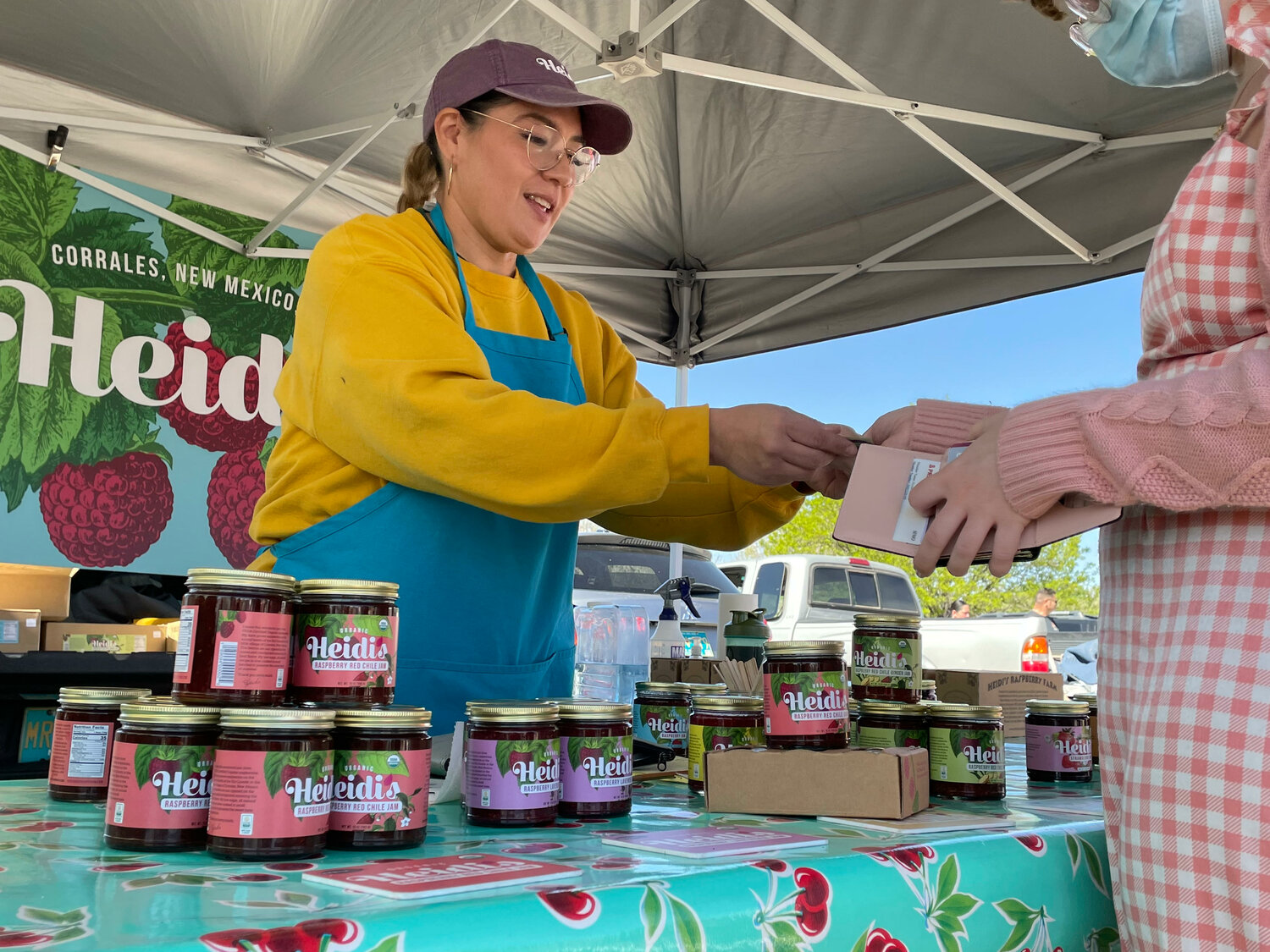 Felisia Montano of Heidi's Raspberry Farm in Corrales sells some jars of jam at the Corrales Growers' Market on April 30. (T.S. Last/Corrales Comment)