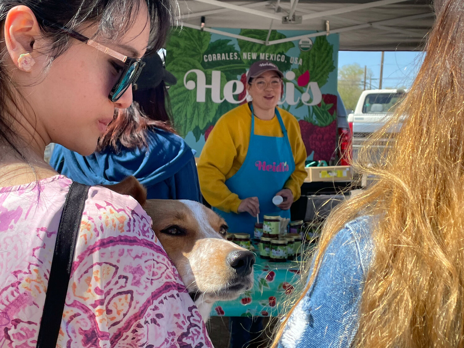 Mei Feng of Rio Rancho holds Nora while waiting in line to purchase jam from Heidi's Raspberry Farms at the Corrales Growers' Market (T.S. Last/Corrales Comment)