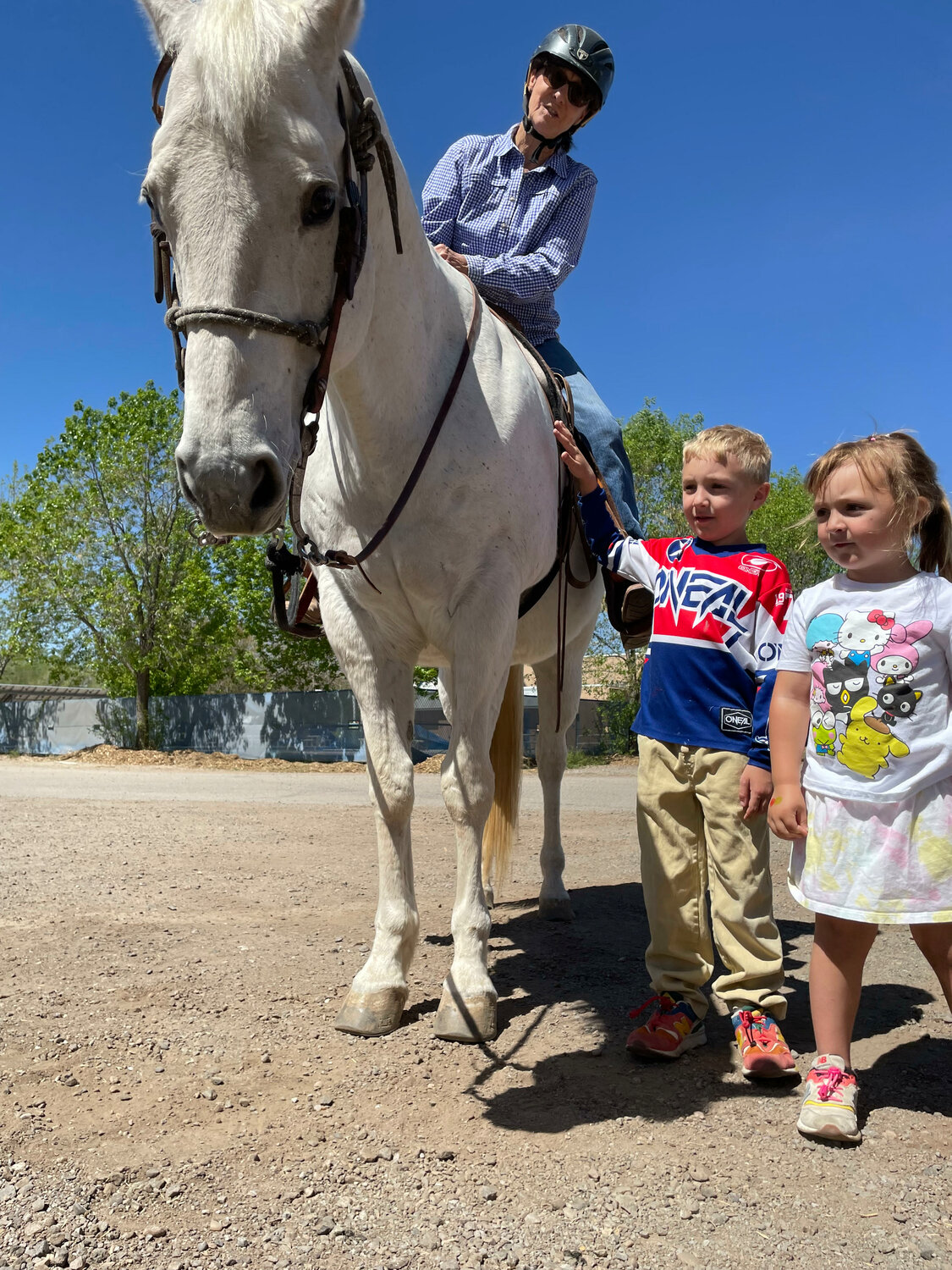 Jack and Leni Rogers pet Willy the horse, riden by Patty Carroll, after participating in the bike rodeo at the Rides, Strides and Giddy-up recreation fair in Corrales last Sunday. (T.S. Last/Corrales Comment)