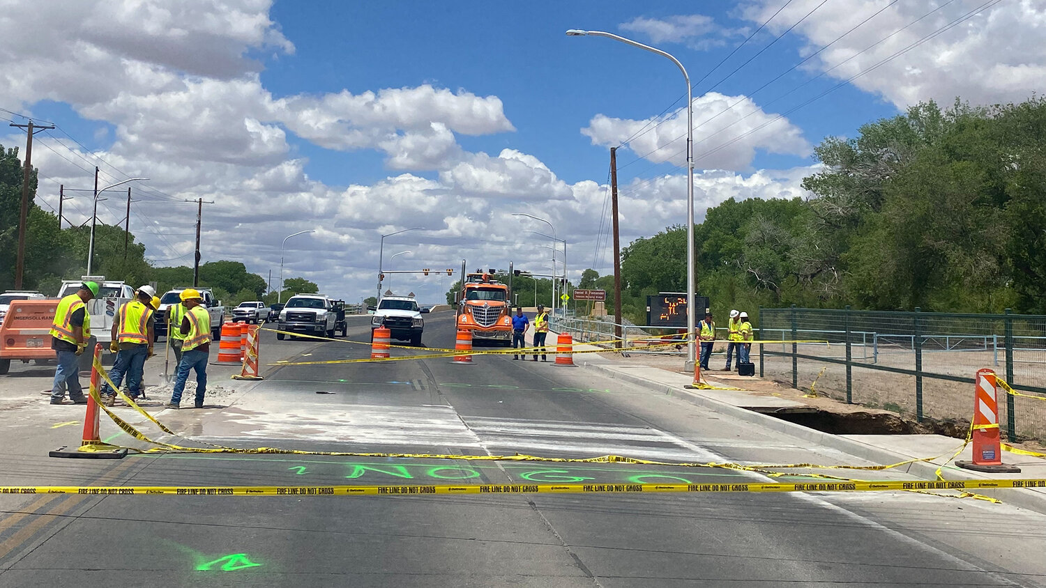 NM DOT workers added cones, warning tape and bright green "NO GO" paint to an area around a sinkhole that briefly trapped two pedestrians over the weekend.