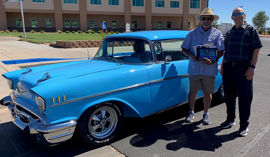 Sandoval County Commissioner Michael Meek, Chair, District 3 stands with John Mora and his 1957 Chevy Belair that earned the Best In Show award.