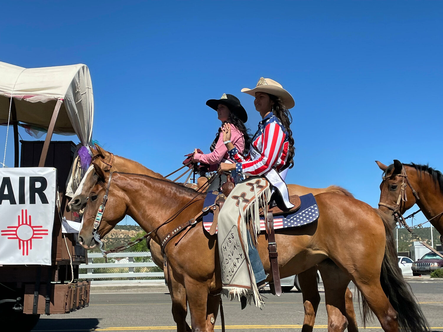 2024 Sandoval County Queen Audrianna Casaus, left, and 2023 Queen Emma Ortiz, right, lead the Queen's Court down the main street in Cuba, Casaus' hometown.