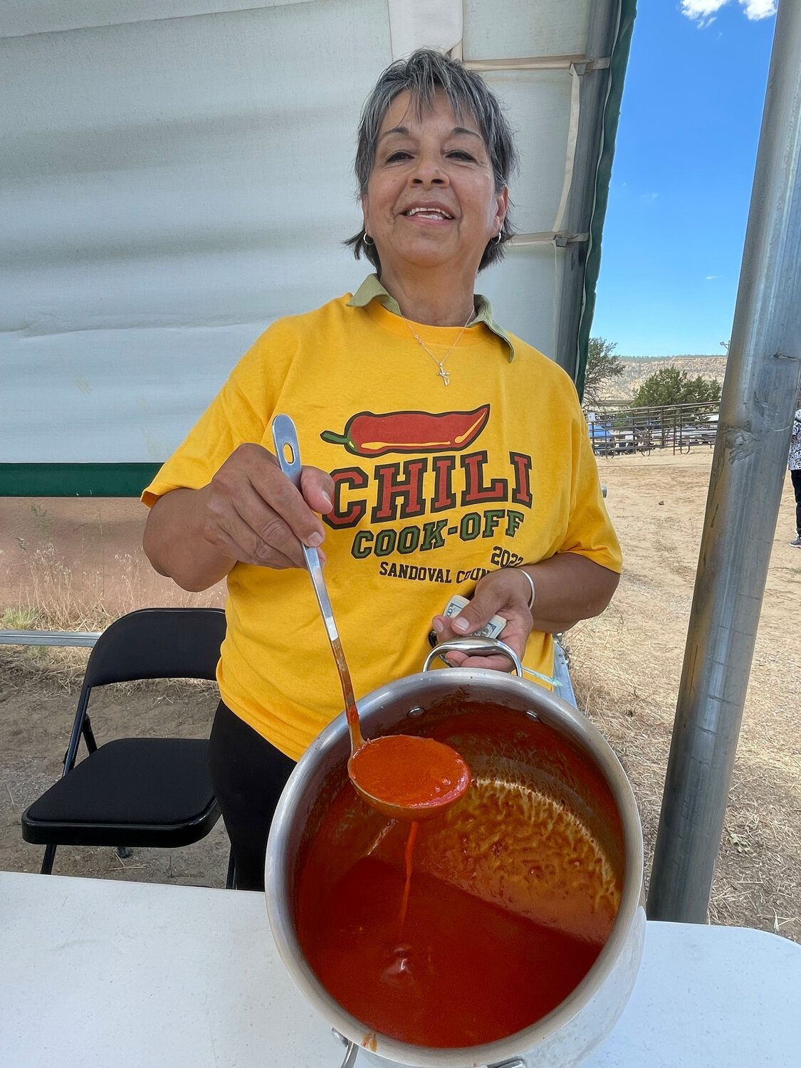 Eloyda Romero, of Cuba, shows off what's left over of her award-winning chili. She won chili cookoff at this year's Sandoval County Fair, the first time the event was held at the fair. She used pork, red chile pods, garlic cloves and a secret ingredient to win the title.