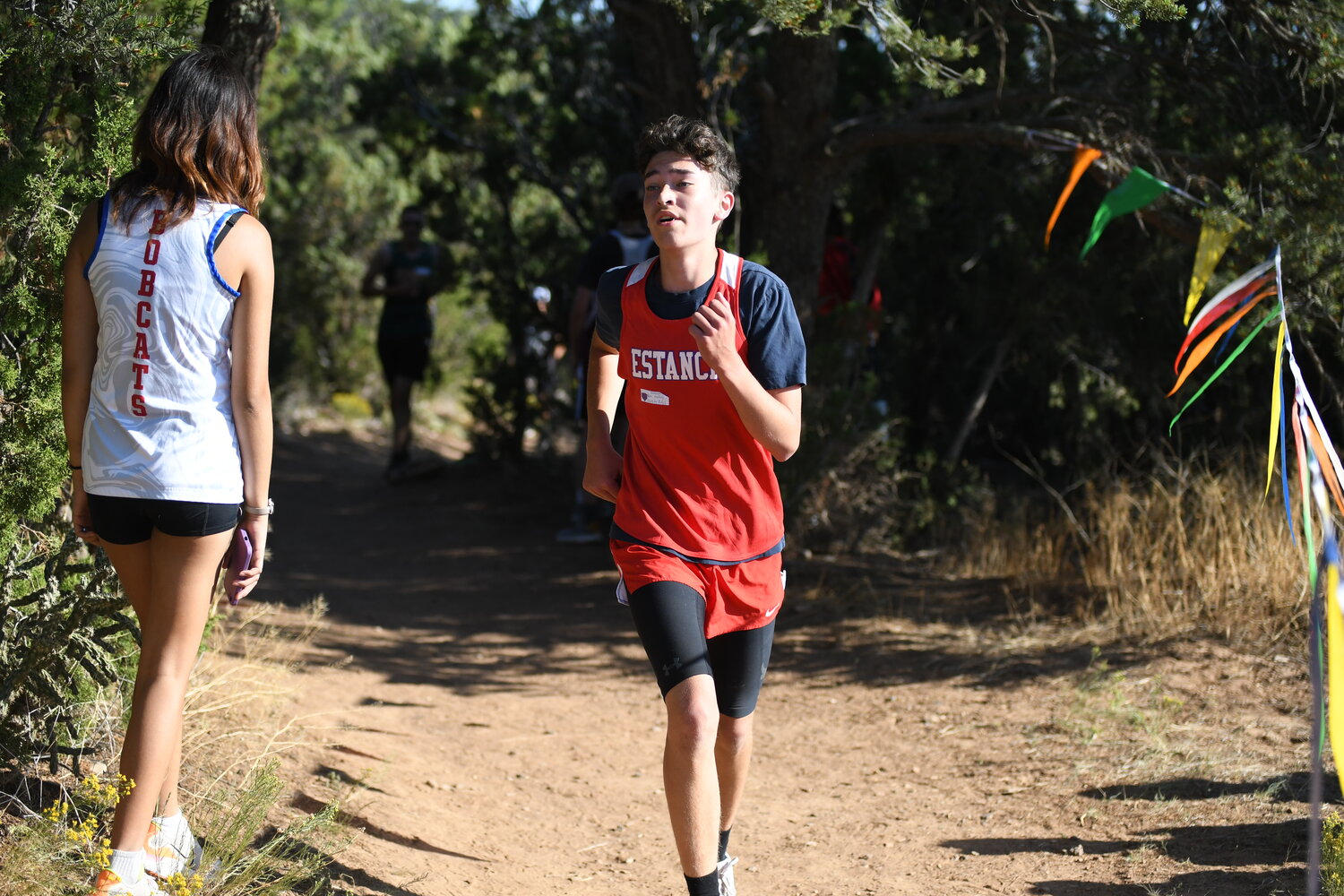 Estancia's Stephen Barela emerges from the woods during the boys varsity race at last week's Nick Martin Memorial Invite.