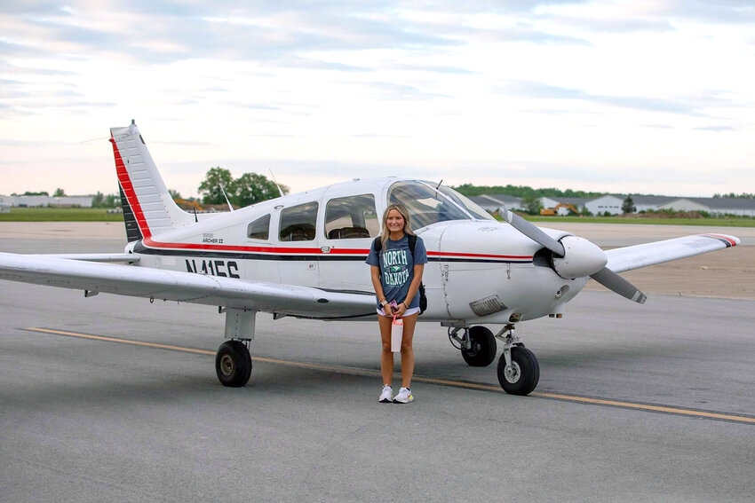 Allie Giezie is pictured by her plane after completing her first solo cross country flight.
