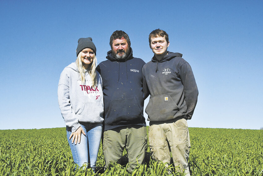 The Mulherns — Emma, Cory and Riley — stand in a field of winter rye May 3 on their farm near Fountain, Minnesota. Mulhern Dairy does not feed any alfalfa in the ration fed to 1,050 cows.