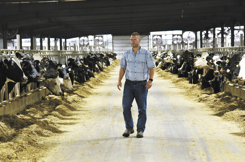 Brent Czech walks through the barn Sept. 6 on his farm near Rice, Minnesota. New Heights Dairy has been crossbreeding their animals since 2006.