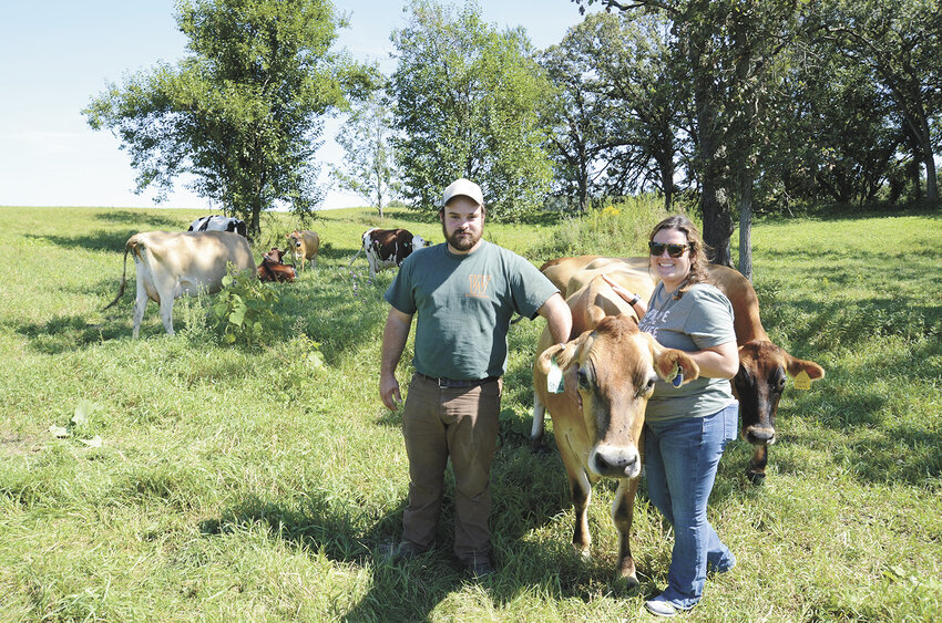 Grant DeYoung and his girlfriend, Madison Epping, take a break to visit cows on pasture Sept. 3 near Woodstock, Illinois. DeYoung launched Cow Valley Creamery last year — a milk processing plant located on his farm where he milks 10 cows.