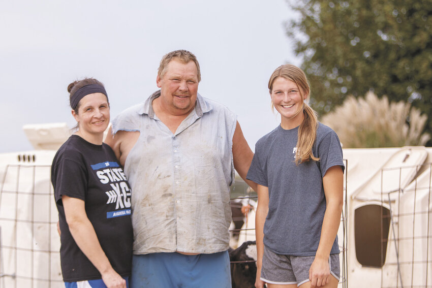 Jody (from left), Doug and Abby Fairbanks pause Sept. 14 on their farm near Anamosa, Iowa. The Fairbanks family milks 400 cows and farms 600 acres.