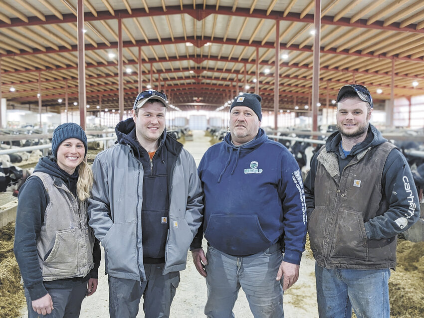 The Mullikin family — Jessica (from left), Brett, Dan and Cody — gathers in their new robot barn Feb. 25 on their farm near Waldo, Wisconsin. The Mullikins milk 480 cows with eight Lely A5 robots and farm 1,200 acres. Not pictured is Dan’s wife, Shelly.