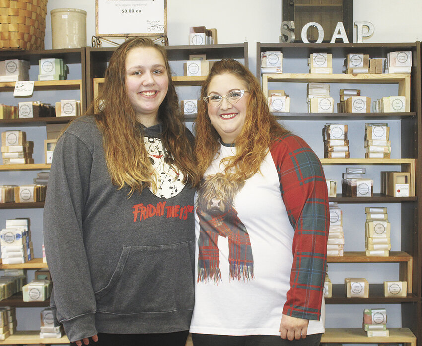 Brianna Baker (left) and Michelle Neathery stand in front of a shelf of goat milk soap Feb. 3 at Little Bull Falls Soap Works in Rothschild, Wisconsin. Neathery started making soap from goat’s milk over 20 years ago because of skin issues plaguing her and her newborn daughter.