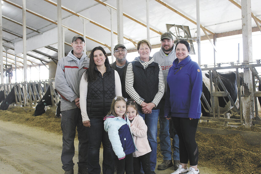 Lexie Opelt (front, from left) and Maggie Van Cuyk; (back, from left) Trent Opelt, Kristan Opelt, Pete Opelt, Jeanne Opelt, Kyle Opelt and Lindsay Van Cuyk stand April 8 in the freestall barn at River Crest Dairy LLC near Greenwood, Wisconsin. The farm is home to 250 milking cows.