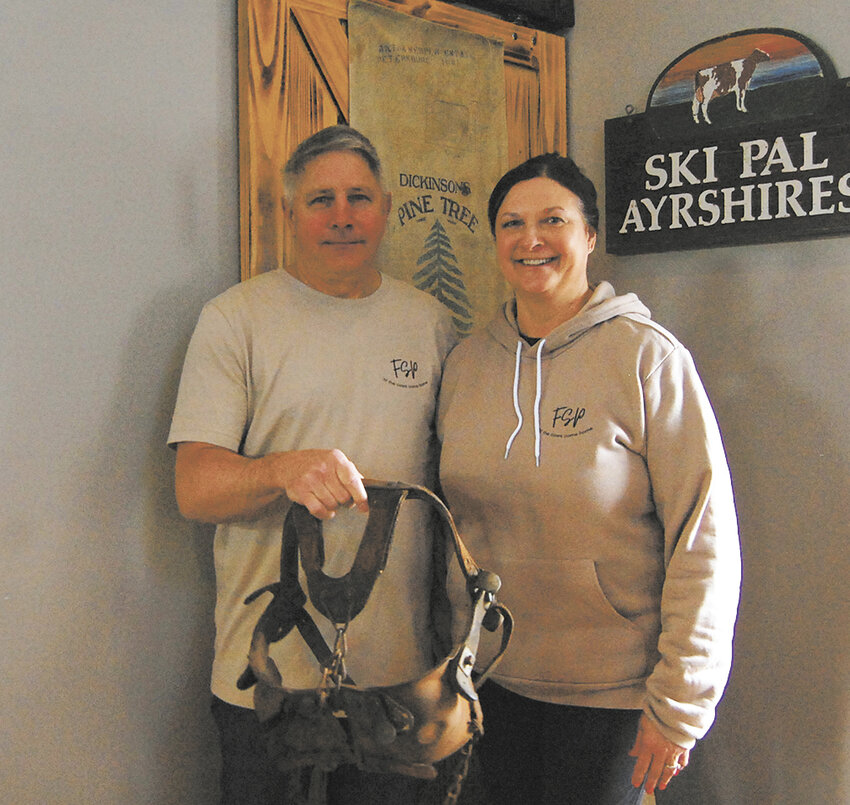 Dave and Karen Koss take a break April 3 at the Feed Store Pub in Epworth, Iowa. The farm sign from the Koss family’s dairy now hangs in the pub, and bull blinders hanging nearby provide a conversation piece.