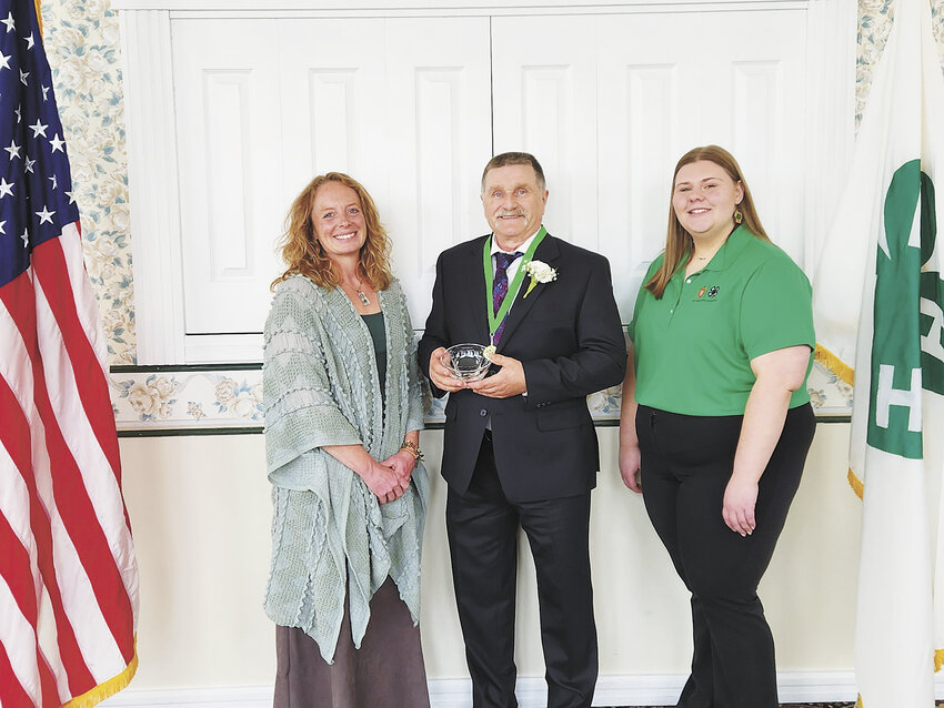 Jessica Jens (from left), Bob Traynor and Juniper Rydberg gather as Traynor is inducted into the Wisconsin 4-H Hall of Fame April 28 in Wisconsin Dells, Wisconsin. Traynor has been a 4-H leader for 39 years.