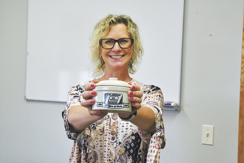Becky Pearson holds a commemorative butter crock June 25 at Plainview Milk Products Cooperative in Plainview, Minnesota. Pearson is the general manager/controller at the cooperative.