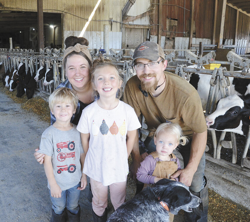 The Adelmeyer family — Abe (front, from left), Elodie and Etta; (back, from left) Callie and Josh — gather in the calf barn on their family’s farm Sept. 26 near Theresa, Wisconsin. The Adelmeyers, along with several members of Josh’s family, milk 180 cows and farm around 1,800 acres at Adelmeyer Farms.