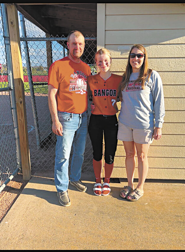 John (from left), Erin and Katie Jones stand May 5 outside the Bangor High School softball dugout  in Bangor, Wisconsin. Erin is a junior on the softball team, and with the help of part-time employees and robotic milking units, John can attend Erin’s games more frequently.