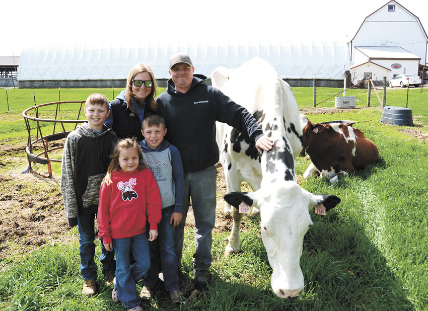 The Hughes family — Chloe (front); (middle, from left) Bryson and Wyatt; (back, from left) Kimberly and Michael — gathers April 30 on their farm near Pickett, Wisconsin. The Hughes family milks 350 cows and farms about 600 acres.