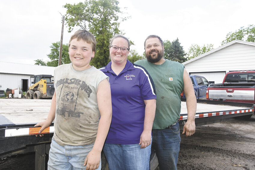 The Tschida family — Carter (from left), Lashana and Chris — gathers June 6 at their farm near St. Rosa, Minnesota. The Tschidas milk 275 cows.