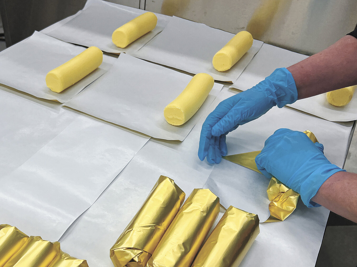 Julie Orchard packages butter in March at Royal Guernsey Creamery near Columbus, Wisconsin. Every roll of butter is hand wrapped in gold foil, and some days, the Orchards package 1,000 rolls of butter.
