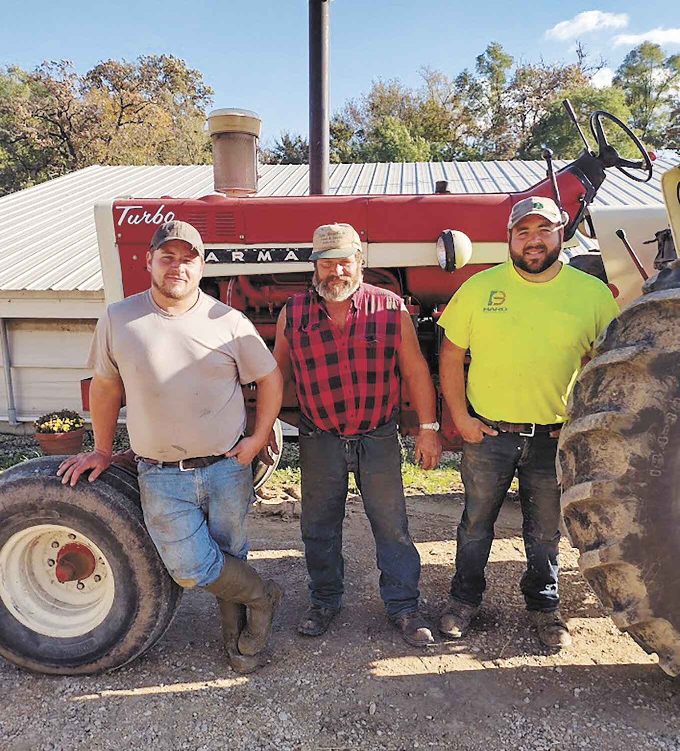Alex (from left), Marvin and Adam Smith take a break Oct. 1 during the Hawkeye Vintage Farm Machinery Club’s annual tractor pull at their farm near Sherrill, Iowa. The Smiths milk 100 cows and host the event every year.