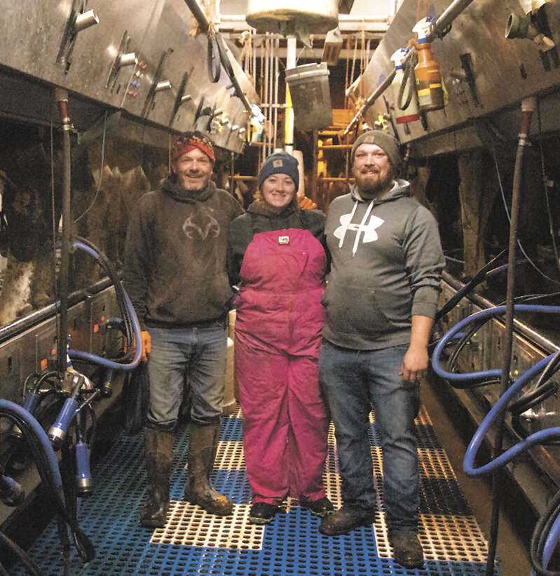 Dennis Burkle (from left), Mindy Burkle and Adrian Spores take a break Nov. 1 in their parlor at their farm near Earlville, Iowa. Spores is Mindy’s boyfriend and helped with morning milking before heading to his full-time job.