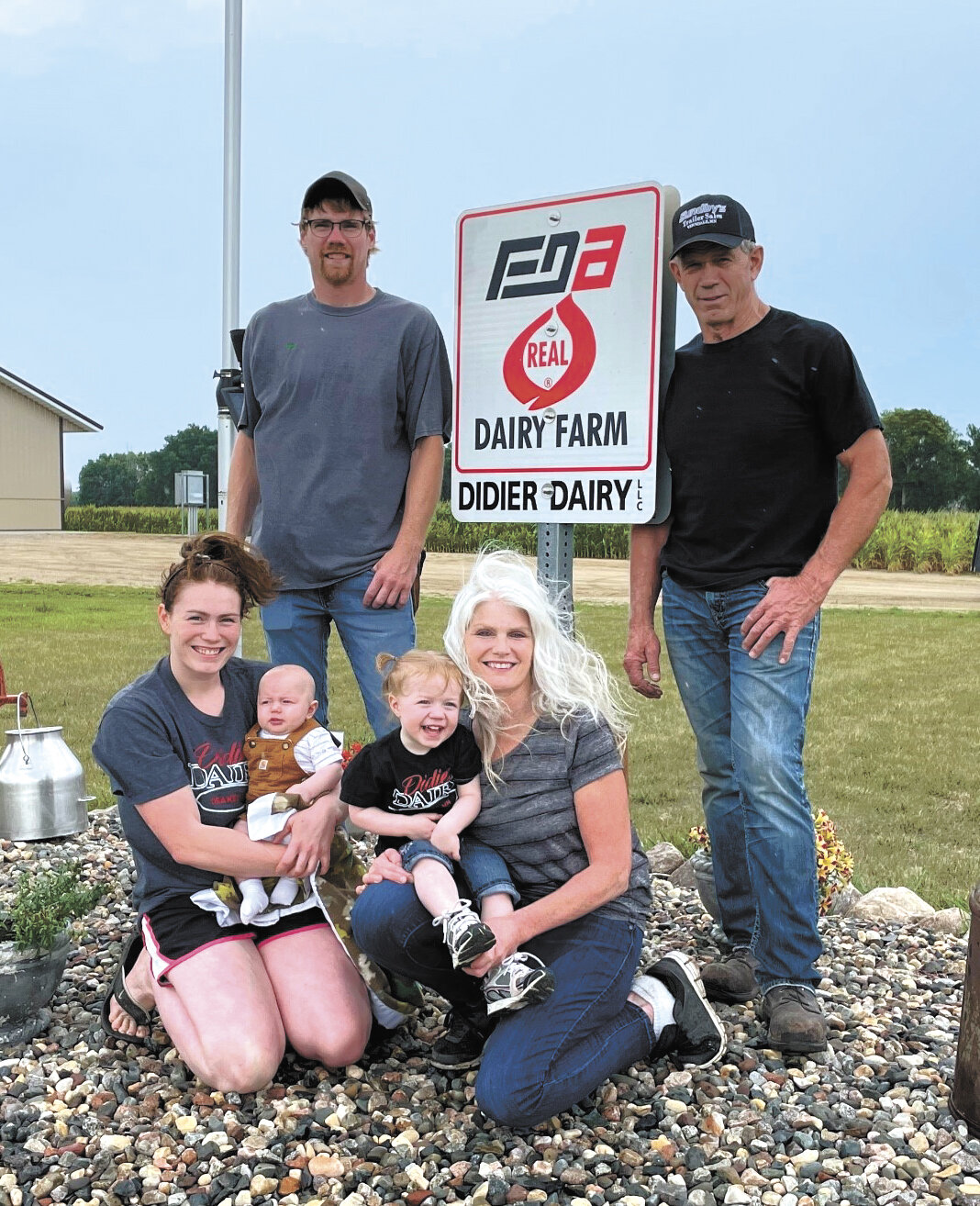 Kayla Bromenshenkel (front, from left), holding Boone Bromenshenkel, and Sharon Didier, holding Keeva Bromenshenkel; (back, from left) Nick Didier and Gerryl “Fritz” Didier stand together on their farm near Osakis, Minnesota. The Didiers milk 120 cows with a robotic milking system.