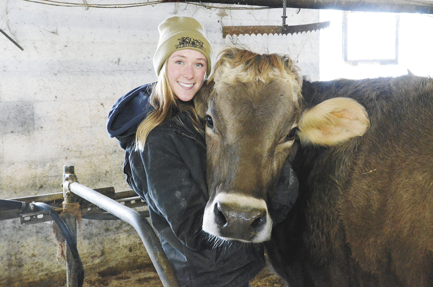 Madalyn Nielsen poses with a favorite Brown Swiss cow Jan. 11 in the tiestall barn on her family’s farm near Lake Mills, Wisconsin. Nielsen began buying Brown Swiss six years ago and now owns 12 head.