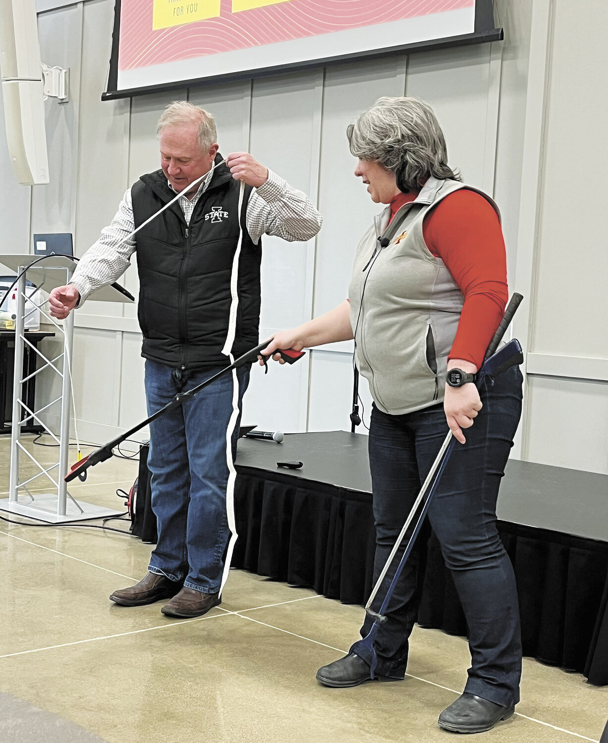 Dr. Phillip Jardon holds a cow measuring tape while Dr. Gail Carpenter demonstrates how to safely grab it Jan. 30 during a Dairy Days workshop in Sioux Center, Iowa. Carpenter said it is essential to monitor the weight of replacement animals throughout all stages of their lives.