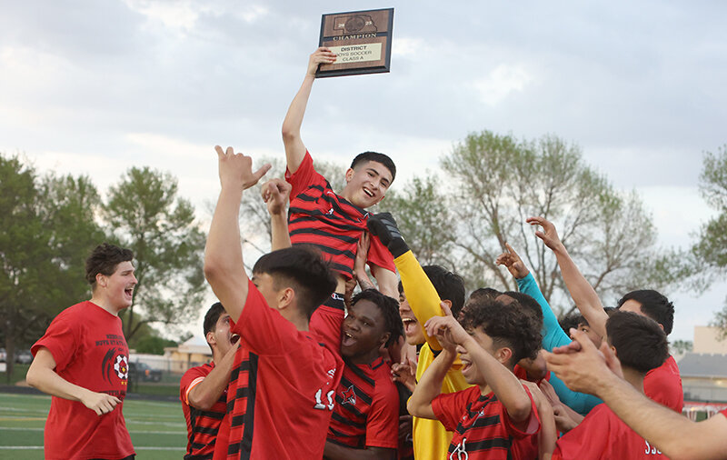 Cesar Alferez is lifted up by his teammates as he holds the district championship plaque following South Sioux City’s 3-1 win over Millard South in the A-5 district championship match at the Cardinal Athletic Complex. The win sends the Cardinals to state for the third straight year.