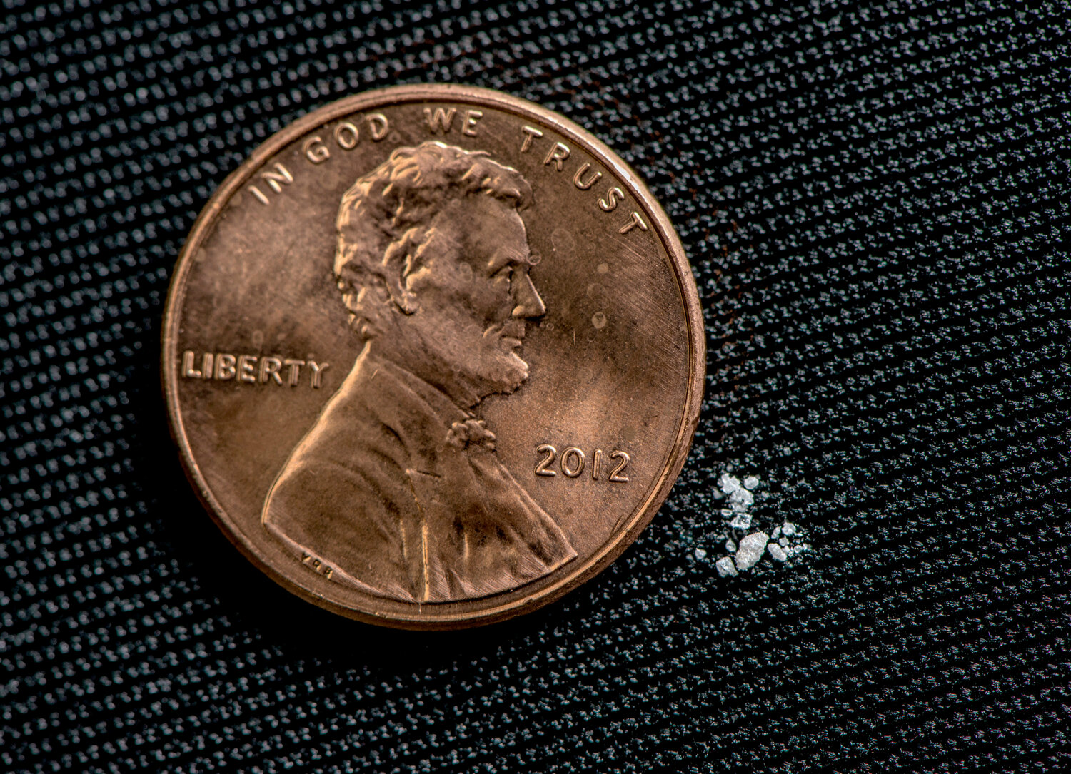 This tiny amount of fentanyl next to the penny is a lethal dose.