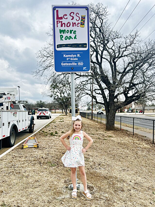 Third grader, Kamdyn Redford, is pictured in front of the Elementary’s new sign from TxDOT that she designed.