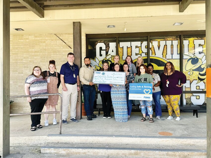 Atmos Energy workers are pictured with Gatesville Primary School employees after the energy company donated $25,000 towards the school’s ECSE (Early Childhood Special Education) playground fundraiser.
