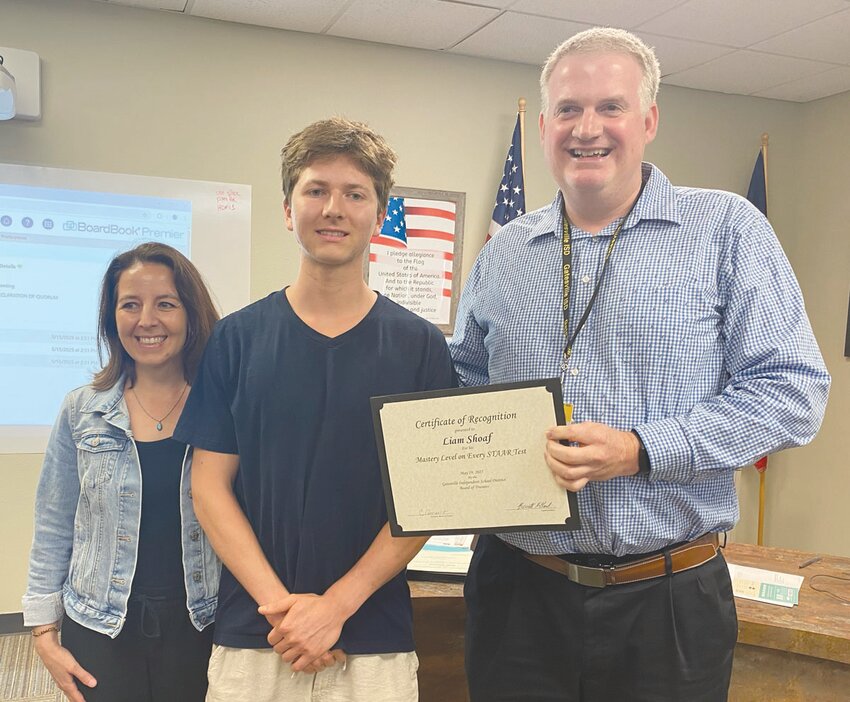 Liam Shoaf, accompanied by his mother, Liz Shoaf, receives a certificate from Dr. Barrett Pollard naming him Student of the Month for May.