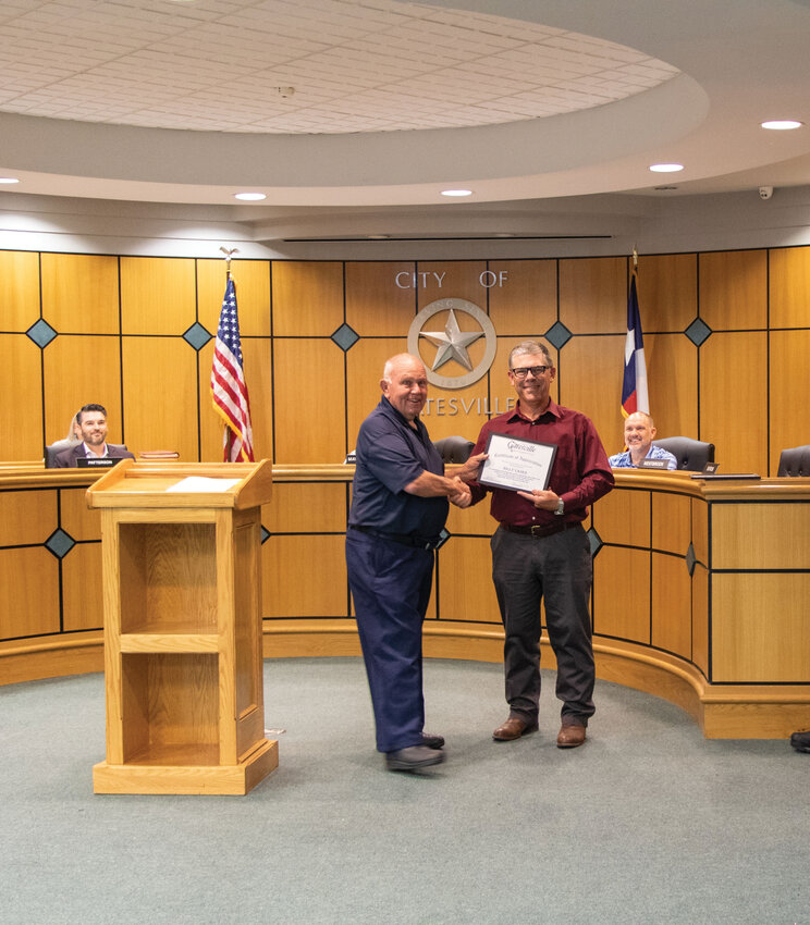 Interim City Manager Brad Hunt (right) presents an award to Fire Chief Billy Vaden (left) at a recent city council meeting. 