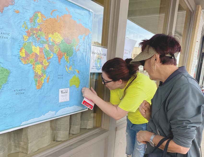 Gatesville Library Director Shea Harp helps Pam Wright to locate the town in New Zealand where she and her husband Ian reside. Those from out-of-state and out-of-country were encouraged to place dots on the map from where they came from to attend the eclipse.
