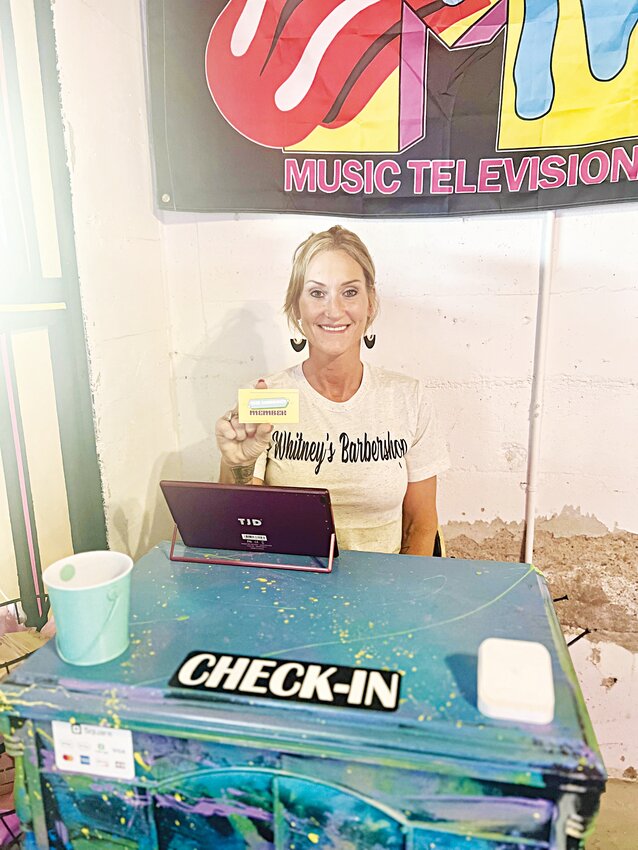 Whitney Williams is pictured at the check-in desk at The Hangout holding a membership card.