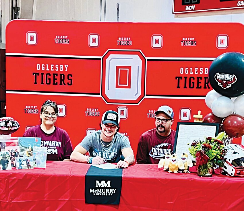 Jakson Tippit is shown signing a letter of commitment with his parents by his side.