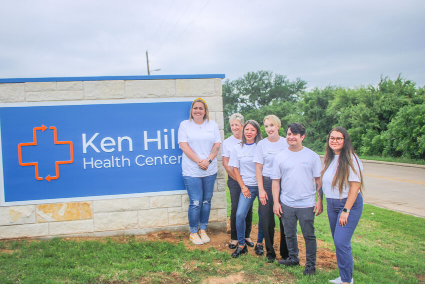 Employees of Ruth’s Place — now Ken Hill Health Center — pose in front of the new sign during the ribbon cutting ceremony May 3.