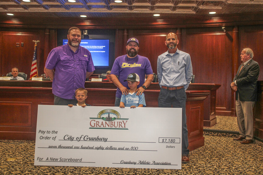Members of the Granbury Athletic Association recently donated a $7,180 check to the city of Granbury to fund a new scoreboard for the Granbury City Park Baseball and Softball Complex.