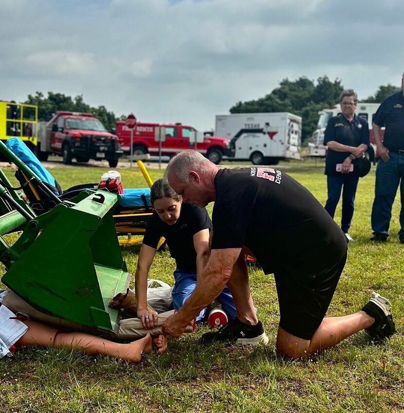 Surgeon Dr. Jennifer Grant instructing North Hood County EMT and firefighter Scott Bullington on proper amputation procedure.