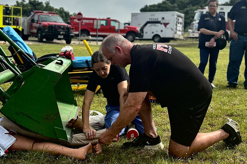 Surgeon Dr. Jennifer Grant instructing North Hood County EMT and firefighter Scott Bullington on proper amputation procedure.